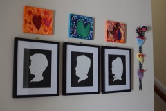 The kids silhouttes with their artwork mounted above them...